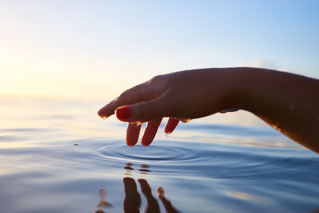 Close up of a hand gently touching water